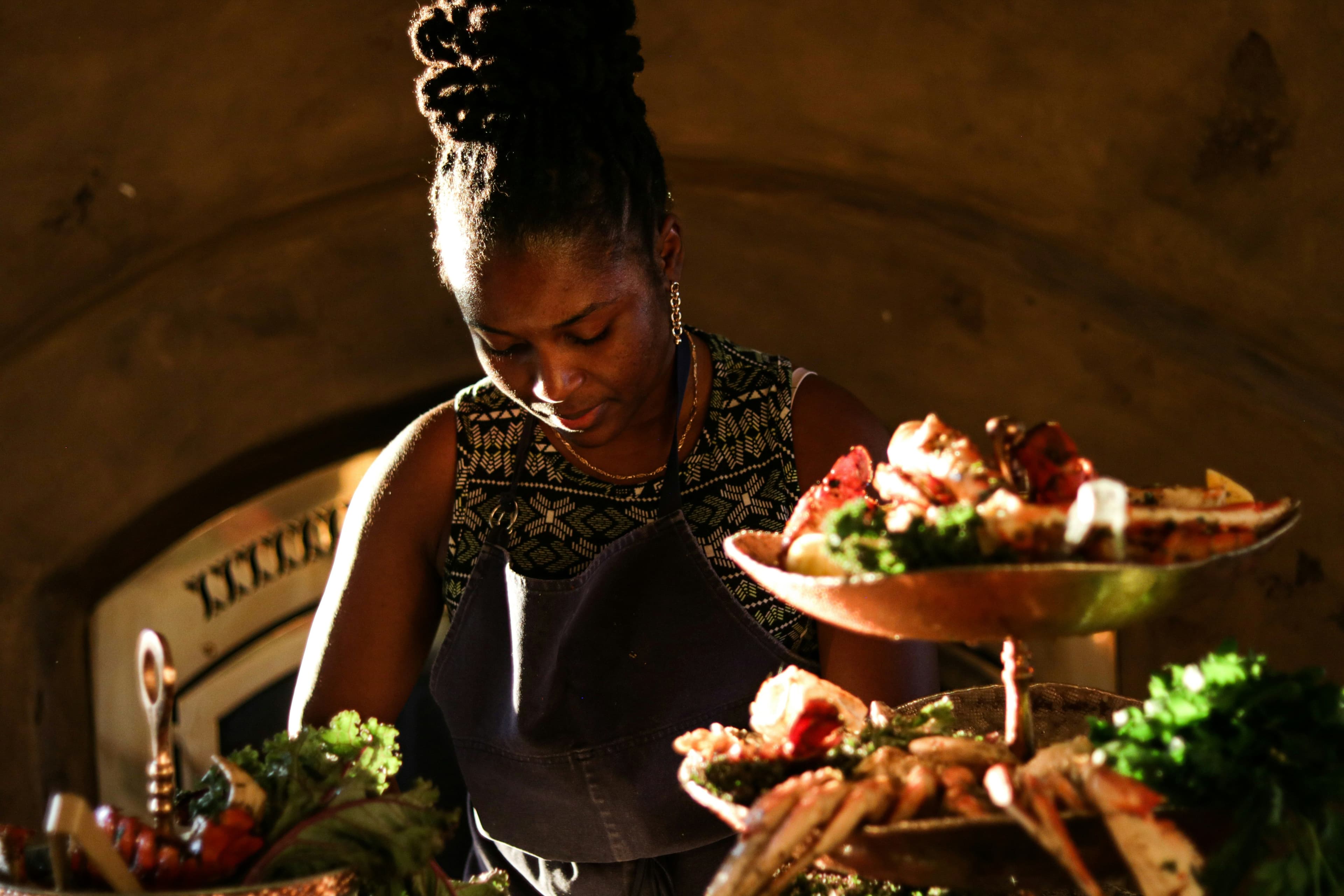 Woman of color cooking a vibrant traditional dish in her kitchen